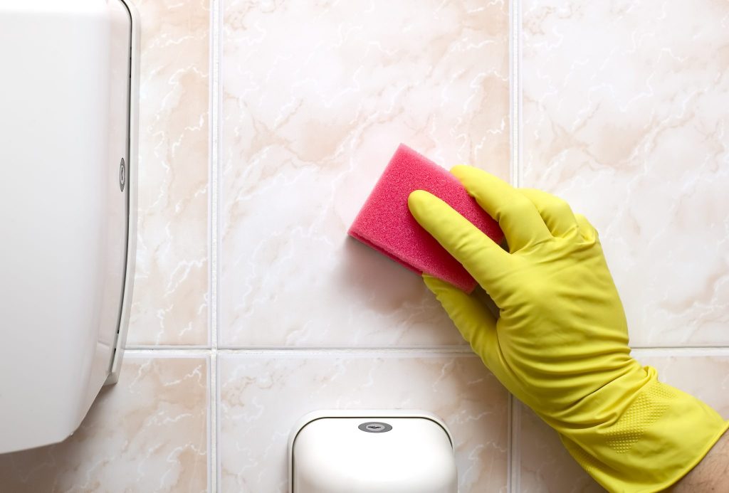 Scrubbing Bathroom Wall with Sponge