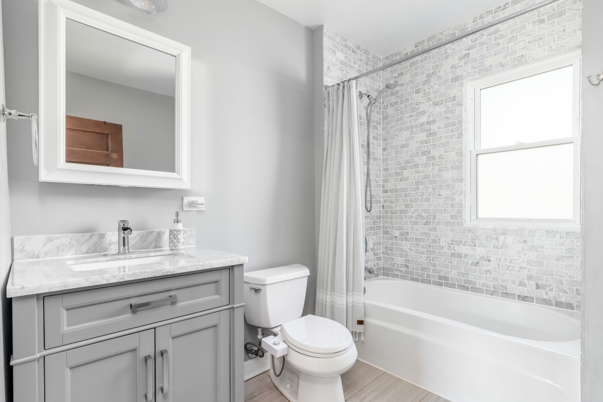 grey bathroom with tub liner, and tiled wall